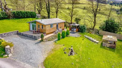a small cabin in the middle of a yard at Haven Lodge Kirkby In Furness, with views to the estuary and hot tub, ideal romantic break in Soutergate