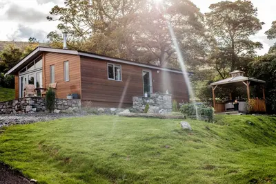 a small house with a garden in front of it at Haven Lodge Kirkby In Furness, with views to the estuary and hot tub, ideal romantic break in Soutergate