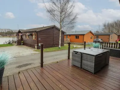 a wooden deck with a grill on top of it at Lakeside 18 in Carnforth