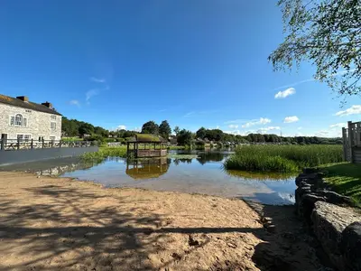 a body of water with a building and a river at Lakeside 18 in Carnforth