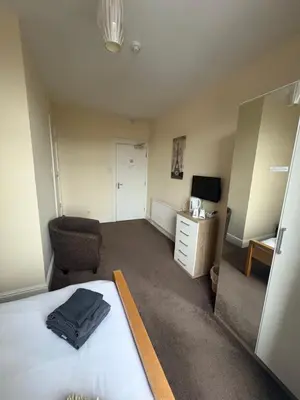 a bedroom with a bed and a chair and a desk at The Harbour Inn in Barrow in Furness