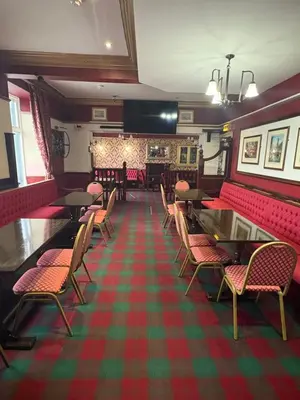 a restaurant with red chairs and tables in a room at The Harbour Inn in Barrow in Furness
