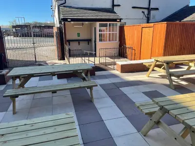 a picnic table and benches on a patio at The Harbour Inn in Barrow in Furness