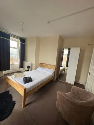 a bedroom with a bed and a chair in it at The Harbour Inn in Barrow in Furness
