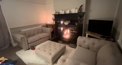 a living room with a couch and a fireplace at Lilac Cottage in Farington