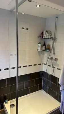 a shower with a glass door in a bathroom at Lilac Cottage in Farington