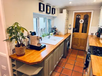 a kitchen with a counter with a sink and a window at Lilac Cottage in Farington