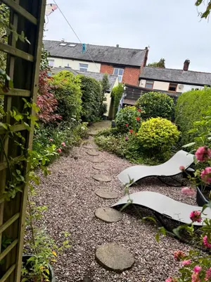 a garden path with rocks and flowers at Lilac Cottage in Farington