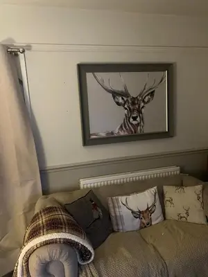 a picture of a deer on the wall above a couch at Lilac Cottage in Farington