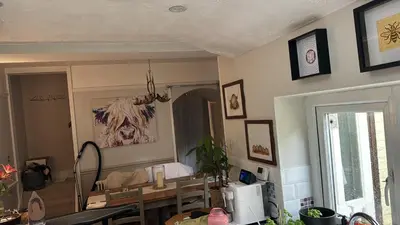 a living room with a table and a microwave at Lilac Cottage in Farington
