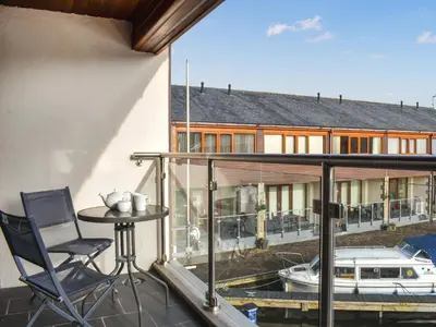 a balcony with a table and a boat at Marina Haven in Carnforth