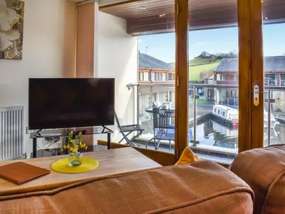 a living room with a television and a large window at Marina Haven in Carnforth
