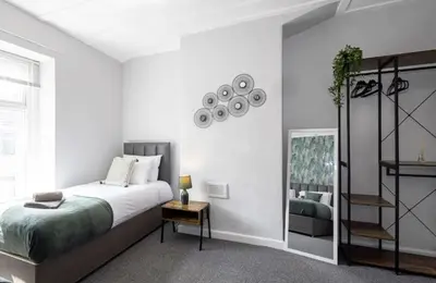 a white bedroom with a bed and a mirror at Cosy 2 Bed House for Contractors in Accrington