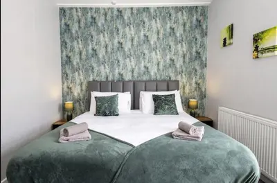 a bedroom with a large bed with two pillows at Cosy 2 Bed House for Contractors in Accrington