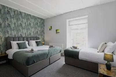a bedroom with two beds and a window at Cosy 2 Bed House for Contractors in Accrington