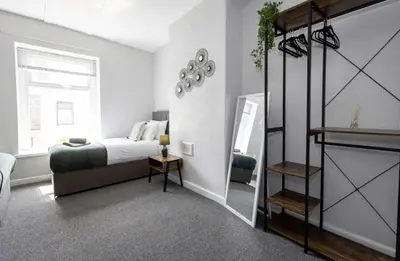 a bedroom with a bed and a mirror at Cosy 2 Bed House for Contractors in Accrington