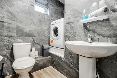 a bathroom with a toilet sink and a washing machine at Roof Terrace WM Smart TV Free Parking in Liverpool