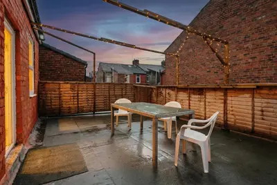 a patio with a wooden table and two chairs at Roof Terrace WM Smart TV Free Parking in Liverpool