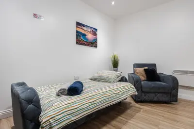 a bedroom with a bed and a couch and a chair at Roof Terrace WM Smart TV Free Parking in Liverpool