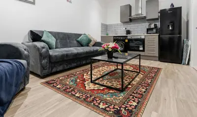a living room with a couch and a table at Near LFC & City Budget LongTerm Free Parking in Liverpool