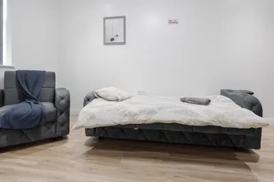 a bed and a chair in a room at Near LFC & City Budget LongTerm Free Parking in Liverpool