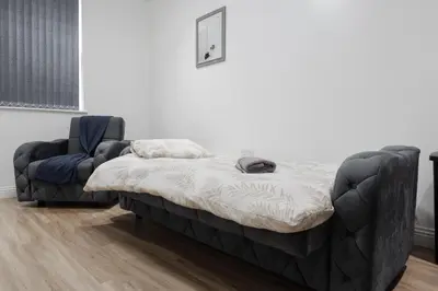 a bed and a chair in a room at Near LFC & City Budget LongTerm Free Parking in Liverpool