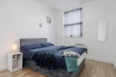 a white bedroom with a bed and a window at Near LFC & City Budget LongTerm Free Parking in Liverpool