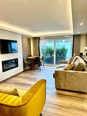 a living room with a yellow couch and a table at Scallop Lodge Lytham in Lytham St Annes