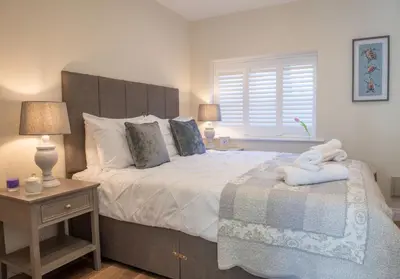 a bedroom with a large bed and a window at Scallop Lodge Lytham in Lytham St Annes