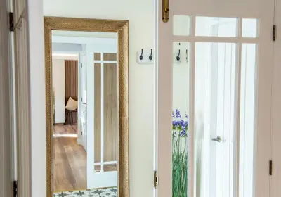 a mirror on a wall next to a door at Scallop Lodge Lytham in Lytham St Annes