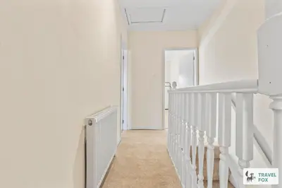 a hallway with white walls and white stairs at Miriam's House in Saint Helens