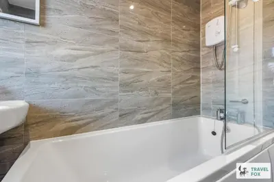 a bathroom with a tub and a sink at Miriam's House in Saint Helens