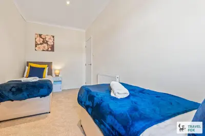 a bedroom with two beds and a desk at Miriam's House in Saint Helens