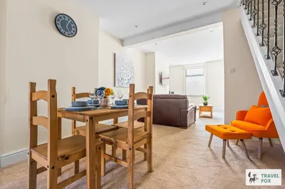 a dining room and living room with a table and chairs at Miriam's House in Saint Helens