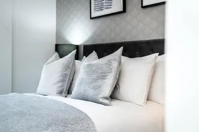 a white bed with white pillows on it at Chavasse Cove Sleeping 6 Guests With Parking in Liverpool