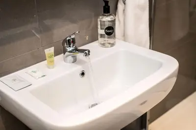 a bathroom sink with a bottle of soap on it at Chavasse Cove Sleeping 6 Guests With Parking in Liverpool