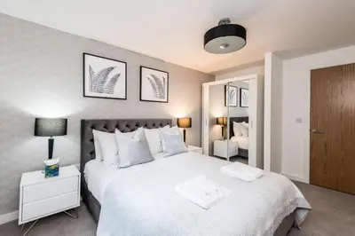 a bedroom with a large white bed with a night stand at Chavasse Cove Sleeping 6 Guests With Parking in Liverpool