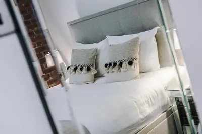a bedroom with a bed with white pillows at Industrial 2BR Apt, Liverpool City Centre Sleeps 8 in Liverpool