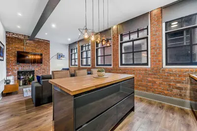 a kitchen with a brick wall and a table at Industrial 2BR Apt, Liverpool City Centre Sleeps 8 in Liverpool