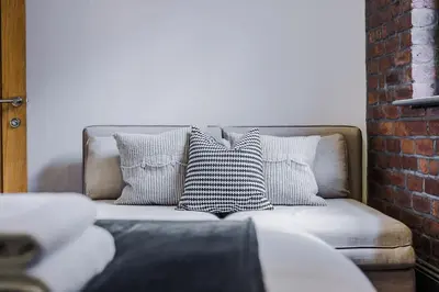 a couch with four pillows on it in a room at Industrial 2BR Apt, Liverpool City Centre Sleeps 8 in Liverpool