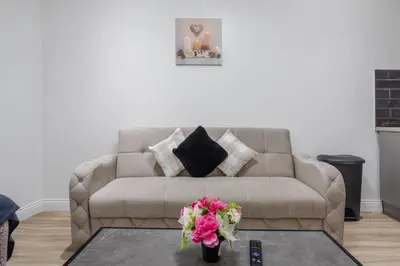 a living room with a couch and flowers on a table at Ideal Work Trips Washer SofaBed Free Parking in Liverpool