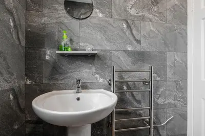 a bathroom with a white sink and a mirror at Ideal Work Trips Washer SofaBed Free Parking in Liverpool