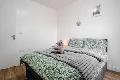 a bedroom with a bed with a teddy bear on it at Ideal Work Trips Washer SofaBed Free Parking in Liverpool