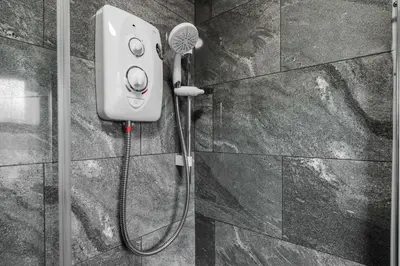 a shower with a blow dryer on a wall at Ideal Work Trips Washer SofaBed Free Parking in Liverpool