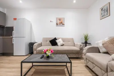 a living room with a couch and a table with flowers at TopFloor Apt LikeHome Long-Term Free Parking in Liverpool