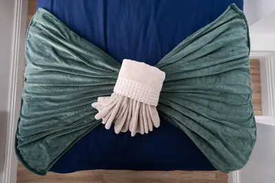 a blanket with a pair of gloves on it at TopFloor Apt LikeHome Long-Term Free Parking in Liverpool