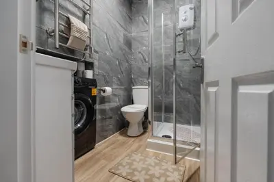 a bathroom with a toilet and a glass shower at TopFloor Apt LikeHome Long-Term Free Parking in Liverpool