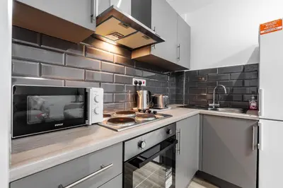 a kitchen with a microwave and a stove top oven at TopFloor Apt LikeHome Long-Term Free Parking in Liverpool