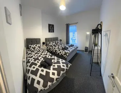 two beds in a room with a camera on a tripod at Anfield cosy stay in Liverpool