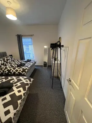 a room with two beds and a camera on a tripod at Anfield cosy stay in Liverpool